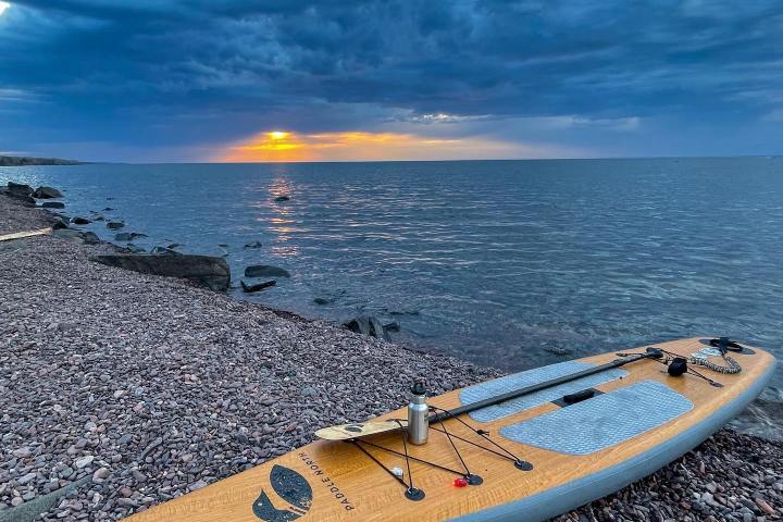 a beach with a paddl board on a body of water