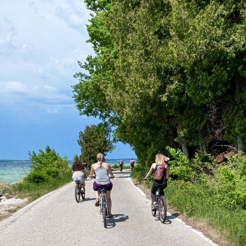 a group of people riding a motorcycle on the side of a road