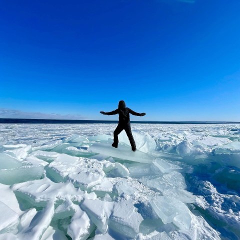 a man riding a snowboard down a snow covered slope