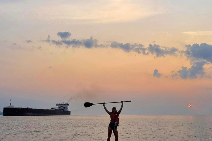 A person standing on a paddleboard on Lake Superior
