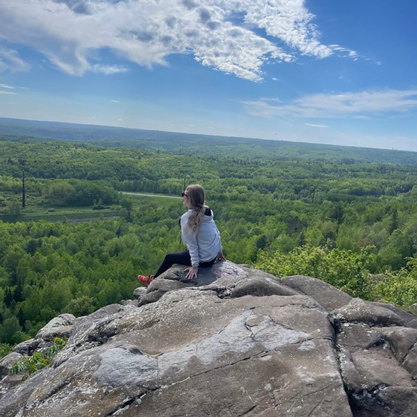 women sitting on top of Ely's Peak during a hike in Duluth, Minnesota