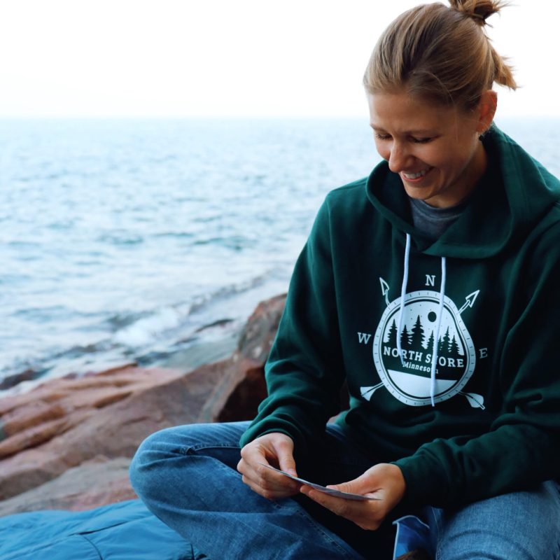 a person sitting next to a body of water playing cards