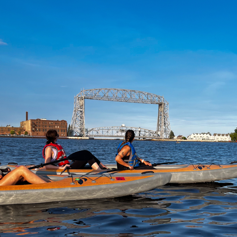 a group of kayakers in front of the Aerial Lift Bridge in Duluth