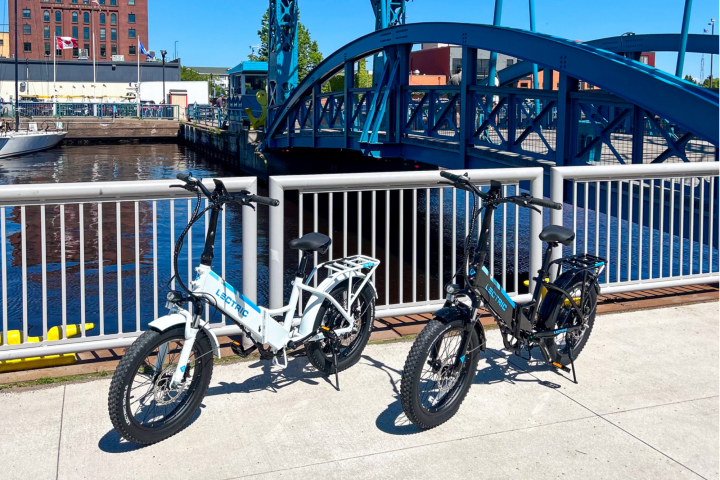 e-bikes parked in front of blue bridge in Canal Park for rent